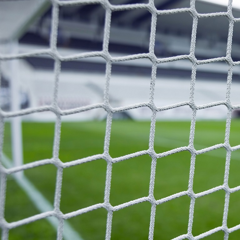 Looking through football goal net at the stadium