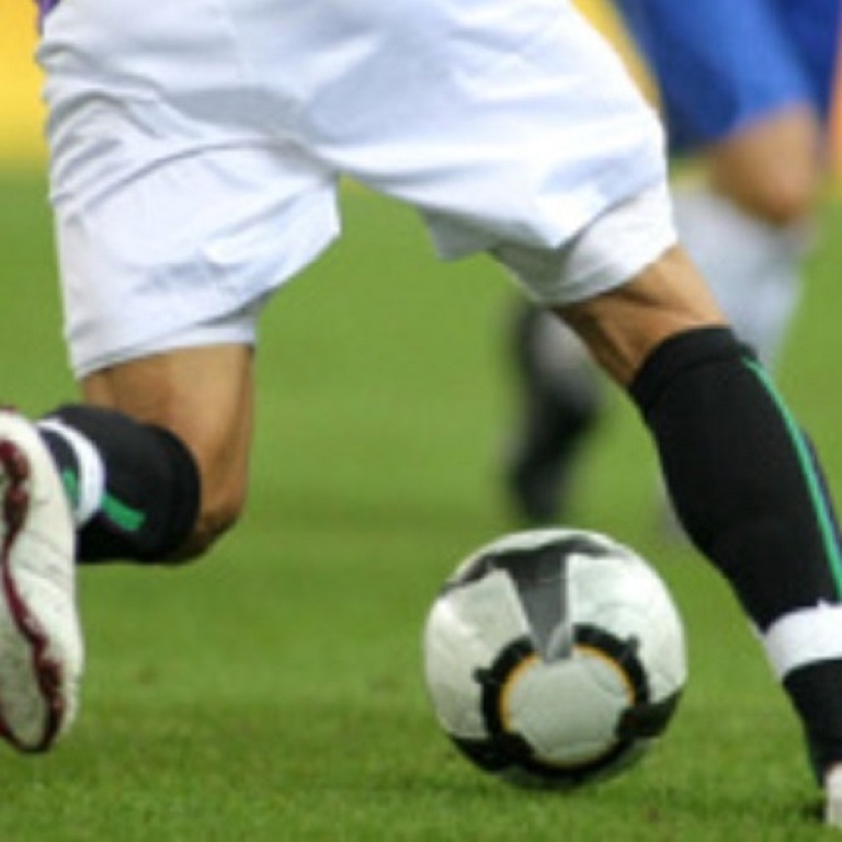 Footballer dribbling a ball in a match